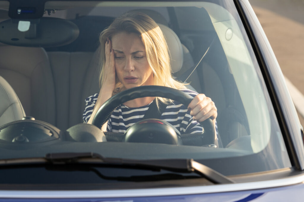 Upset woman of middle age looking at car dashboard. Anxious female driver in broken car out of fuel or petrol. Stressed female forget to fill tank for long ride or road trip. Troubles failure concept